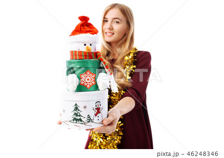 Happy young woman in Santa Claus hat, in hands Happy young woman in Santa Claus hat, in hands 46248346