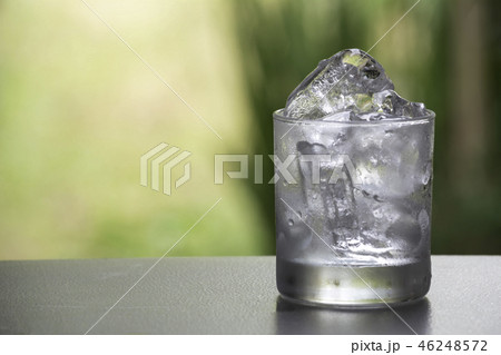 Ice cube in the glass on table with nature Ice cube in the glass on table with nature 46248572