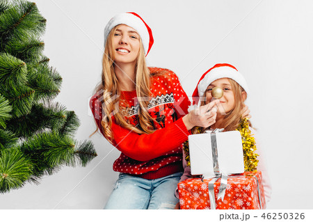 Mom and daughter are wearing Santa Claus hats Mom and daughter are wearing Santa Claus hats 46250326