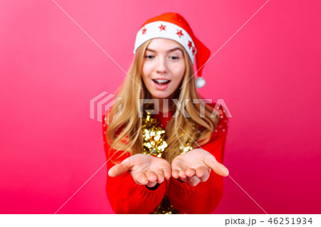 Girl in red sweater, Santa hat and tinsel on neck 46251934