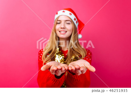 Girl in red sweater, Santa hat and tinsel on neck 46251935