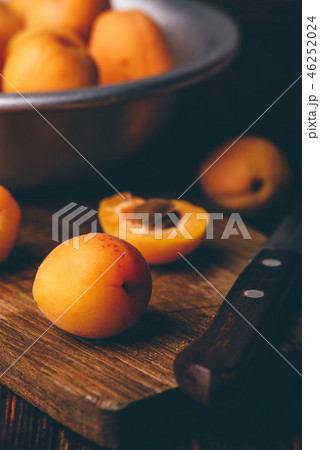 Mellow apricots with knife over cutting board 46252024