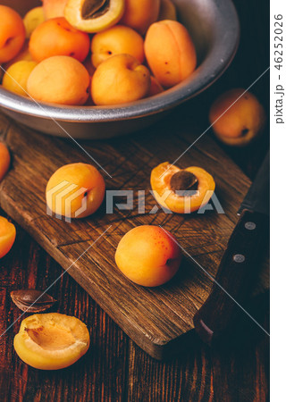 Mellow apricots with knife over cutting board 46252026