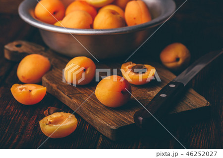 Mellow apricots with knife over cutting board 46252027