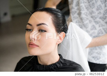 hair stylist drying woman hair with towel in salon 46253012
