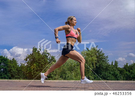 Fit woman running fast for sport on sunny day 46253356
