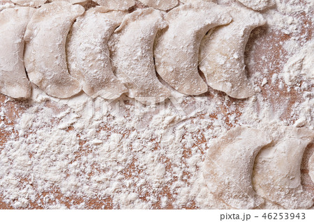 Dumplings with with potato on brown table sprinkled with flour Dumplings with with potato on brown table sprinkled with flour 46253943
