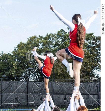 Two high school cheerleaders  held up by ankles 46256147