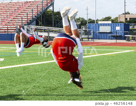 Two cheerleaders flipping 46256148