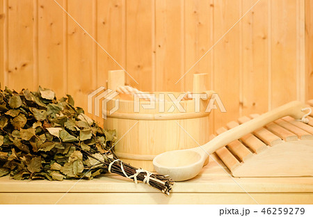 A wooden bucket, a birch broom and other accessories in a finnish classic sauna or russian bath A wooden bucket, a birch broom and other accessories in a finnish classic sauna or russian bath 46259279