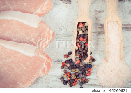 Fresh loin with pepper and salt on spoons Fresh loin with pepper and salt on spoons 46260621