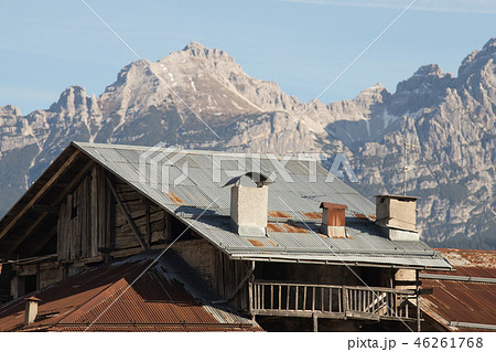 Dolomites. A village house on the background of snowy mountains 46261768