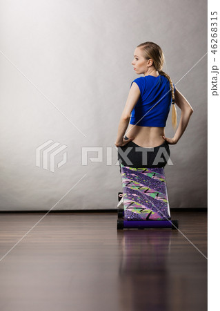 Woman training on bench for sit ups 46268315