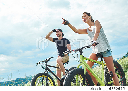 Look at it. A man and a woman are laughing and cycling 46280646