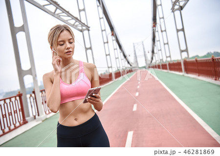 Woman jogger doing cardio workout while listening to music, outdoors. Woman jogger doing cardio workout while listening to music, outdoors. 46281869