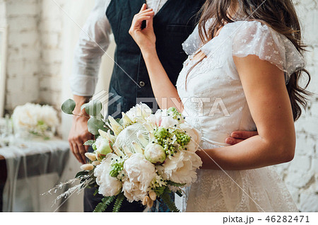 wedding bouquet with peonies in hands of bride wedding bouquet with peonies in hands of bride 46282471