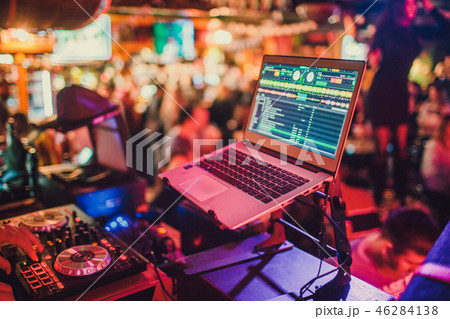 DJ mixing tracks on a mixer in a nightclub. 46284138