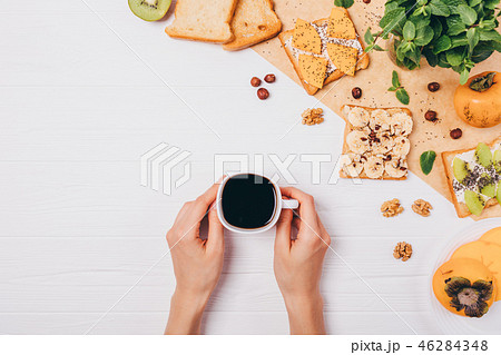 Female's hands holding cup of strong black coffee Female's hands holding cup of strong black coffee 46284348