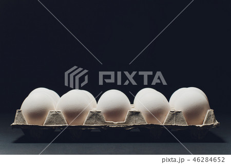 Several white eggs in an egg carton. 46284652