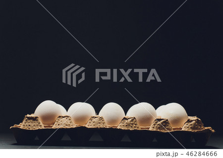 Several white eggs in an egg carton. 46284666