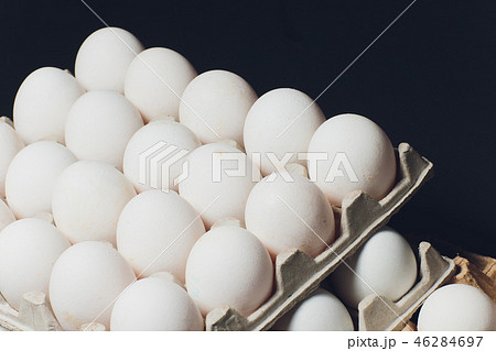 Several white eggs in an egg carton. 46284697