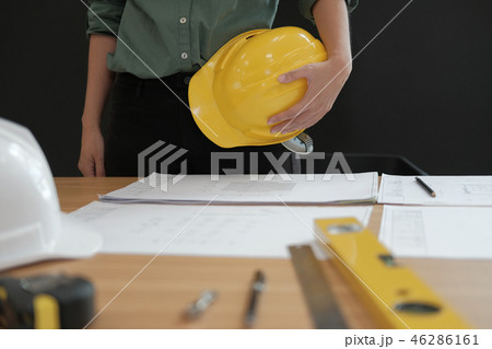 engineer architect worker holding safety helmet hardhat wtih construction blueprint on desk 46286161