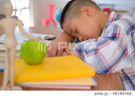 lazy stressed young little asian kid boy resting sleeping on desk. child fall asleep. children tired from studying 46286366