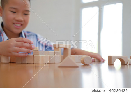 little asian kid boy child children schoolboy playing wood block toy. learning education concept 46286422
