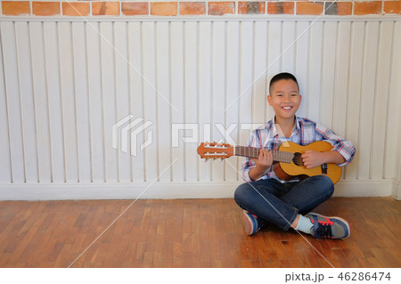 asian kid boy child playing guitar ukulele. children leisure activity asian kid boy child playing guitar ukulele. children leisure activity 46286474