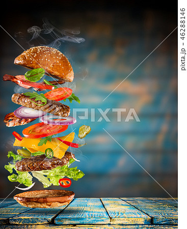 Big tasty burger with flying ingredients. Big tasty burger with flying ingredients. 46288146