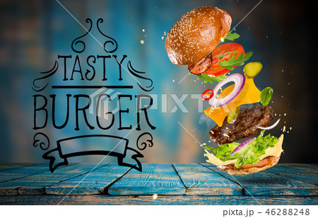 Big tasty burger with flying ingredients. Big tasty burger with flying ingredients. 46288248