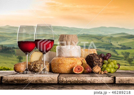 Delicious cheeses with wine on old wooden table. Delicious cheeses with wine on old wooden table. 46289218
