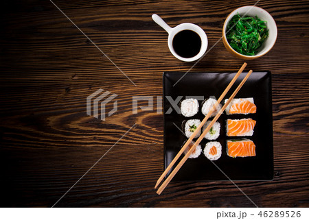 Various kinds of sushi served on wooden table. 46289526