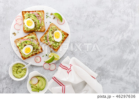 Toasts with avocado guacamole, radish, boiled egg Toasts with avocado guacamole, radish, boiled egg 46297636