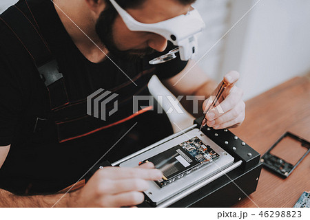 Man Repairing Hardware Equipment in Repair Shop 46298823