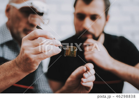 Old and Young Men Work Together in Repair Shop. Old and Young Men Work Together in Repair Shop. 46298838