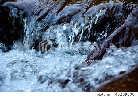 Water surface with ripples and sunrays reflections 46299600