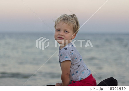 Cute little boy rides a horse on the beach against seaview. Copy space. 46301959