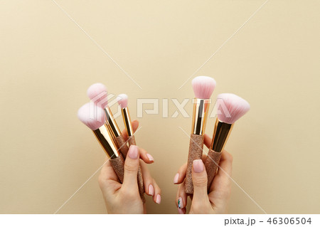Woman's hands holding make up brushes, close up 46306504