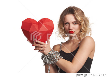 Woman holding red polygonal paper heart shape with tied by chain hands Woman holding red polygonal paper heart shape with tied by chain hands 46307847