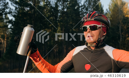 Training an athlete on the roller skaters. Biathlon ride on the roller skis with ski poles, in the Training an athlete on the roller skaters. Biathlon ride on the roller skis with ski poles, in the 46310619