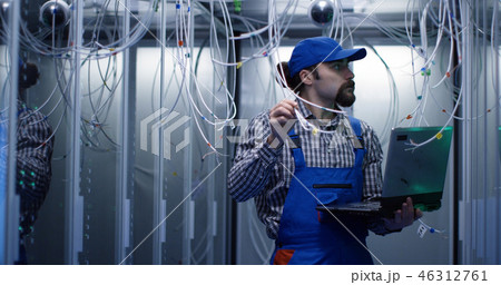 Technician checking cables in a data center 46312761