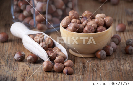 Hazelnuts in a  wooden spoon and wooden bowl 46323758
