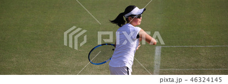 天然芝のコートでフォアハンドストロークを打つジュニアテニスプレイヤー 46324145