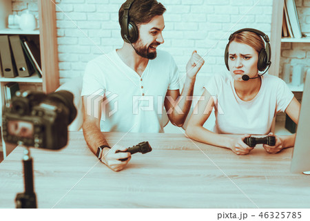 Bloggers playing a video game on console 46325785