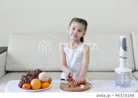 The child cuts apples with a knife. The child cuts apples with a knife. 46328166