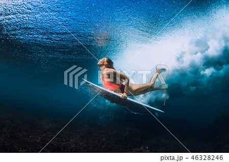 Surfer woman with surfboard dive underwater 46328246