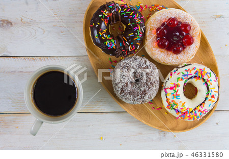Donut in tray with black coffee. Donut in tray with black coffee. 46331580