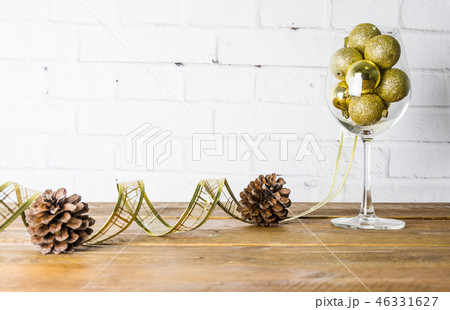 Glistening golden balls in a glass of wine. Glistening golden balls in a glass of wine. 46331627