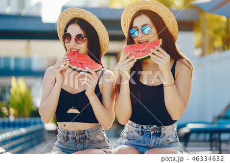 two girls eating watermelon 46334632